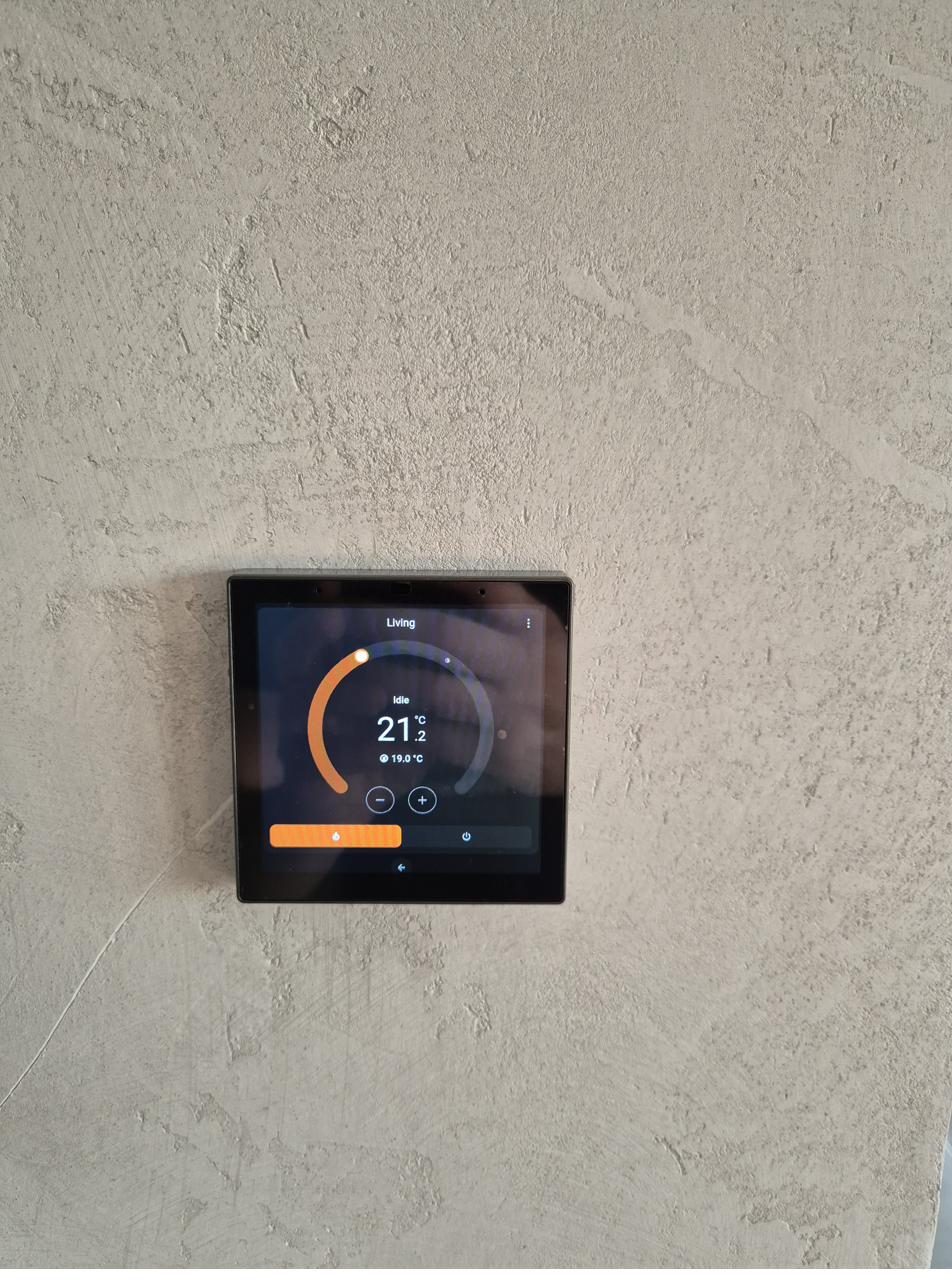 Termostat inteligent montat pe perete texturat — control climatizare pe cameră